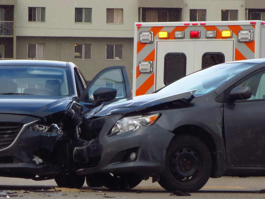 Two cars involved in an accident, with an ambulance in the back.