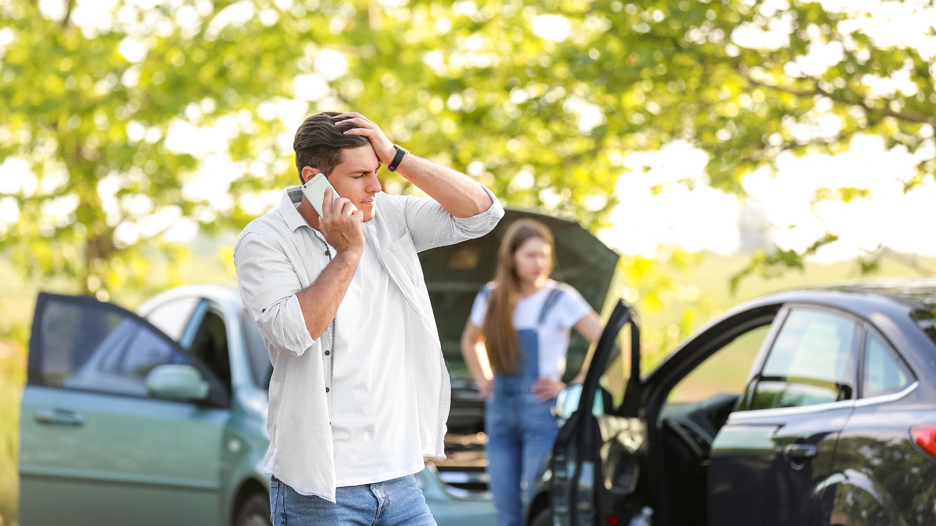 A man on the phone after getting into a car accident.