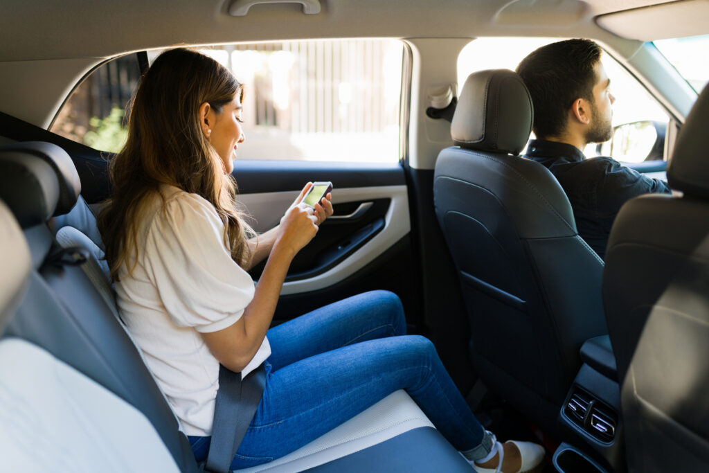 A woman on her phone during a rideshare ride.