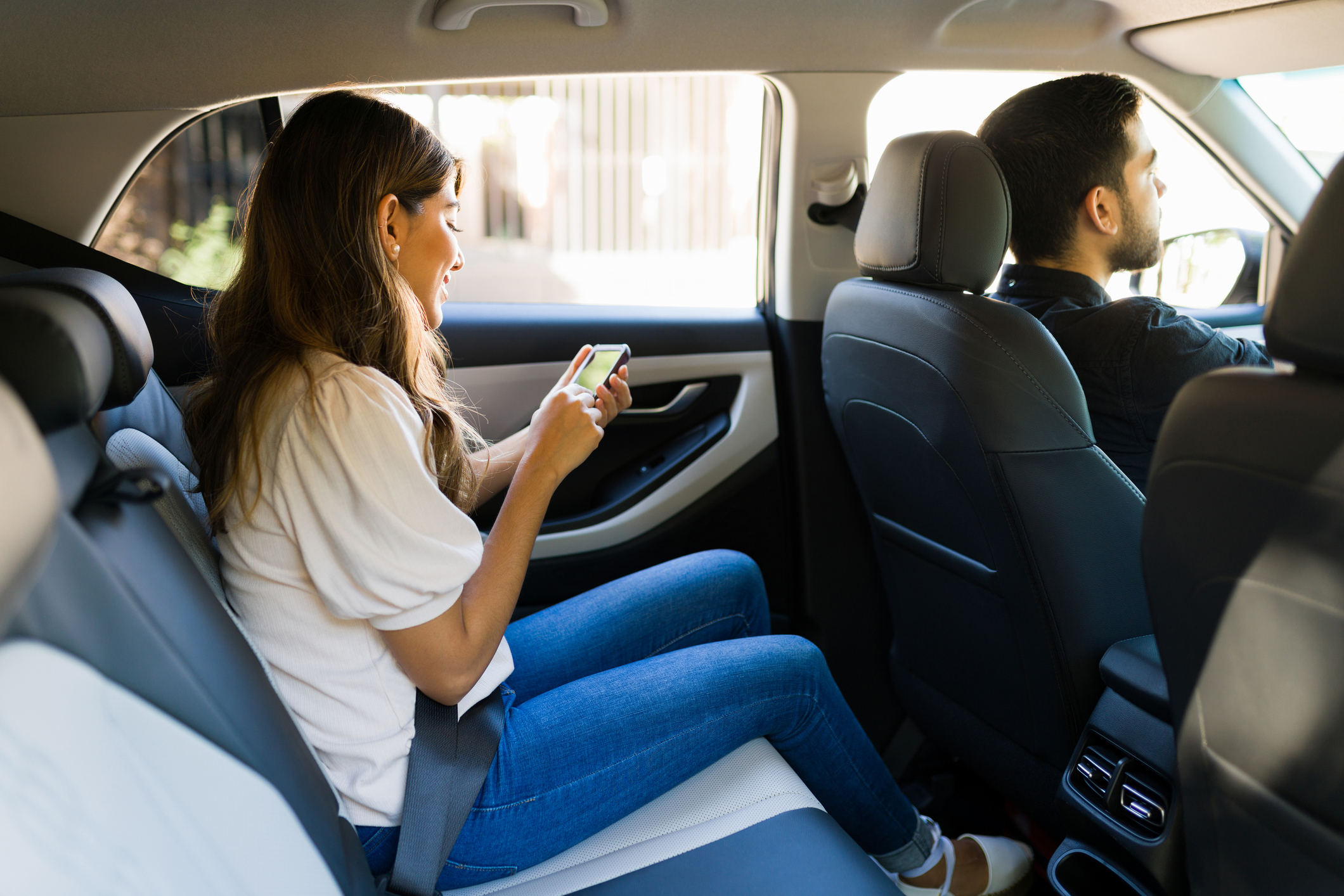 A woman on her phone during a rideshare ride.