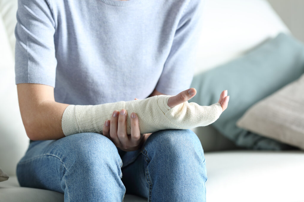 A person sitting down with a broken arm.