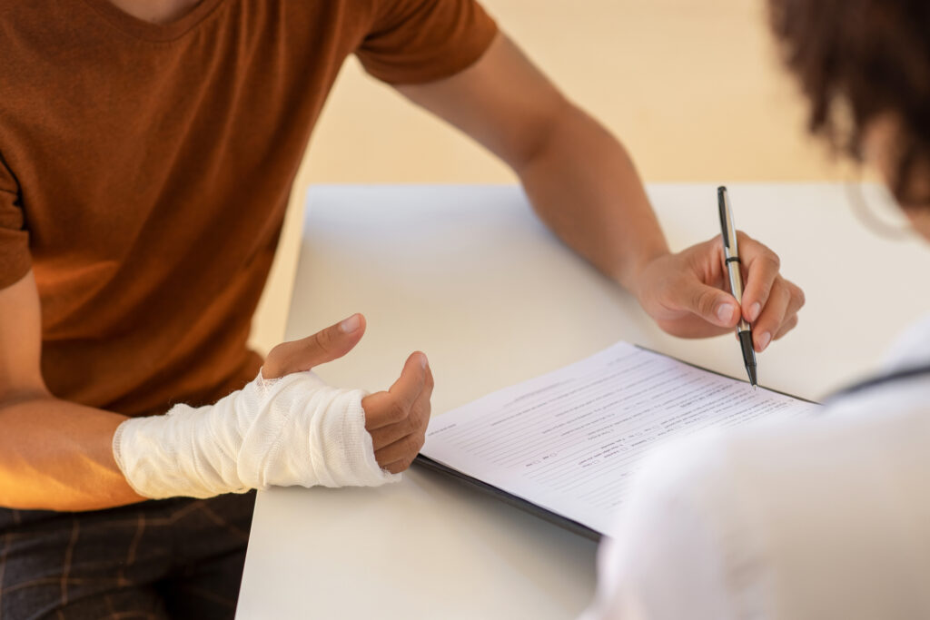 A man with a broken arm signing a document with his non-dominant hand. 
