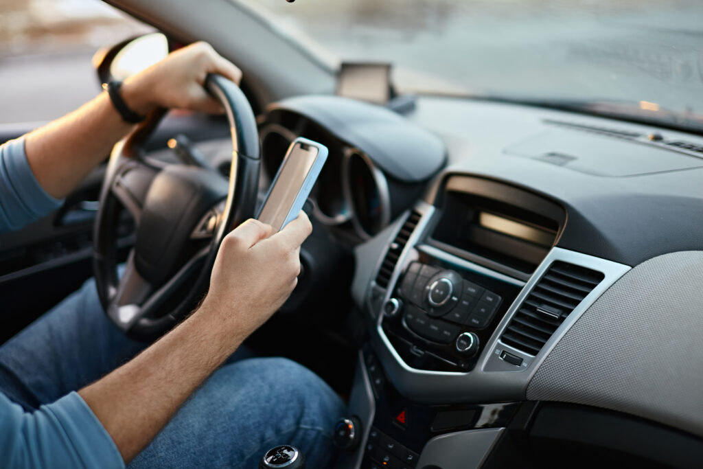 A man using his phone while behind the wheel.