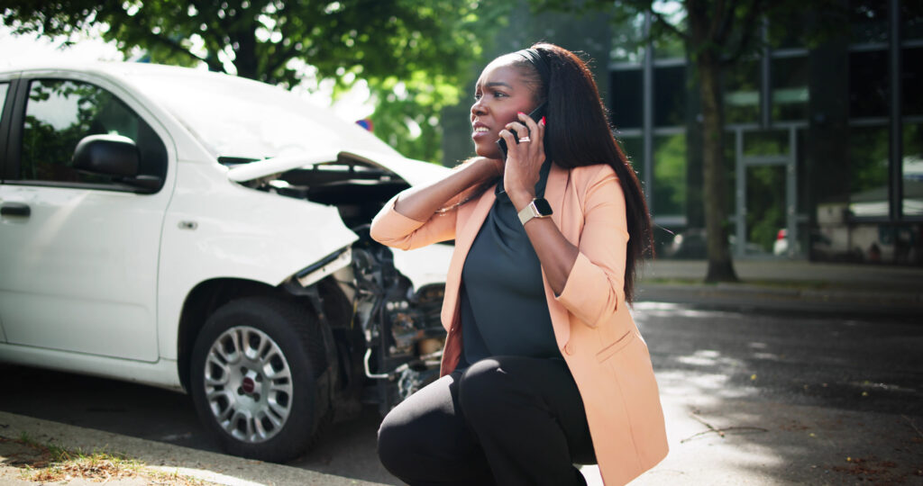 A woman on the phone after getting into a car accident.