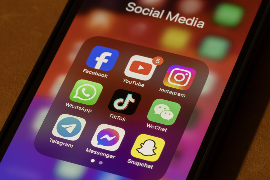 A phone with a folder of social media apps.