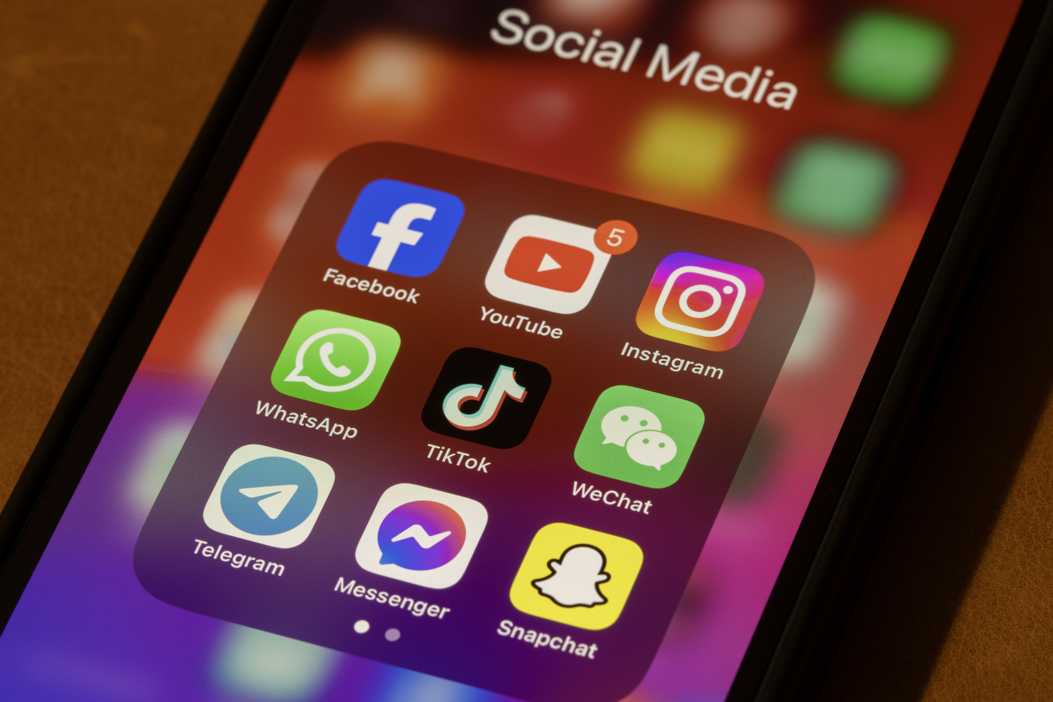A phone with a folder of social media apps.