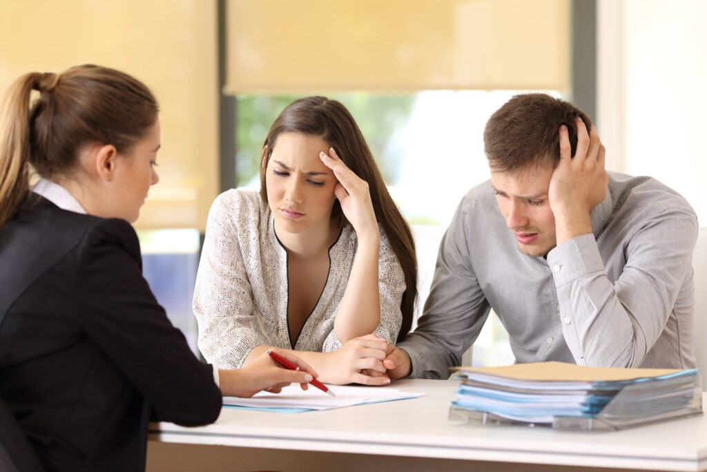 A confused couple talking to an attorney.