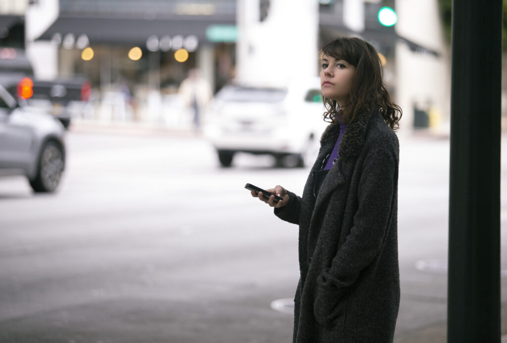 A woman patiently waiting for an Uber.