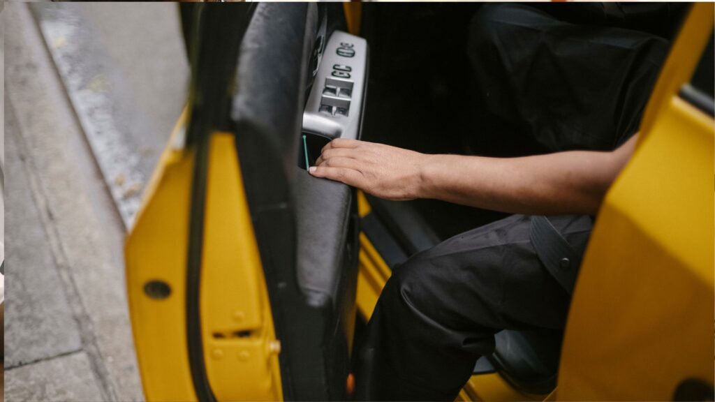 A person getting out of a yellow car.