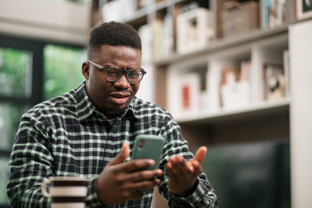 A man looking confused on his phone.