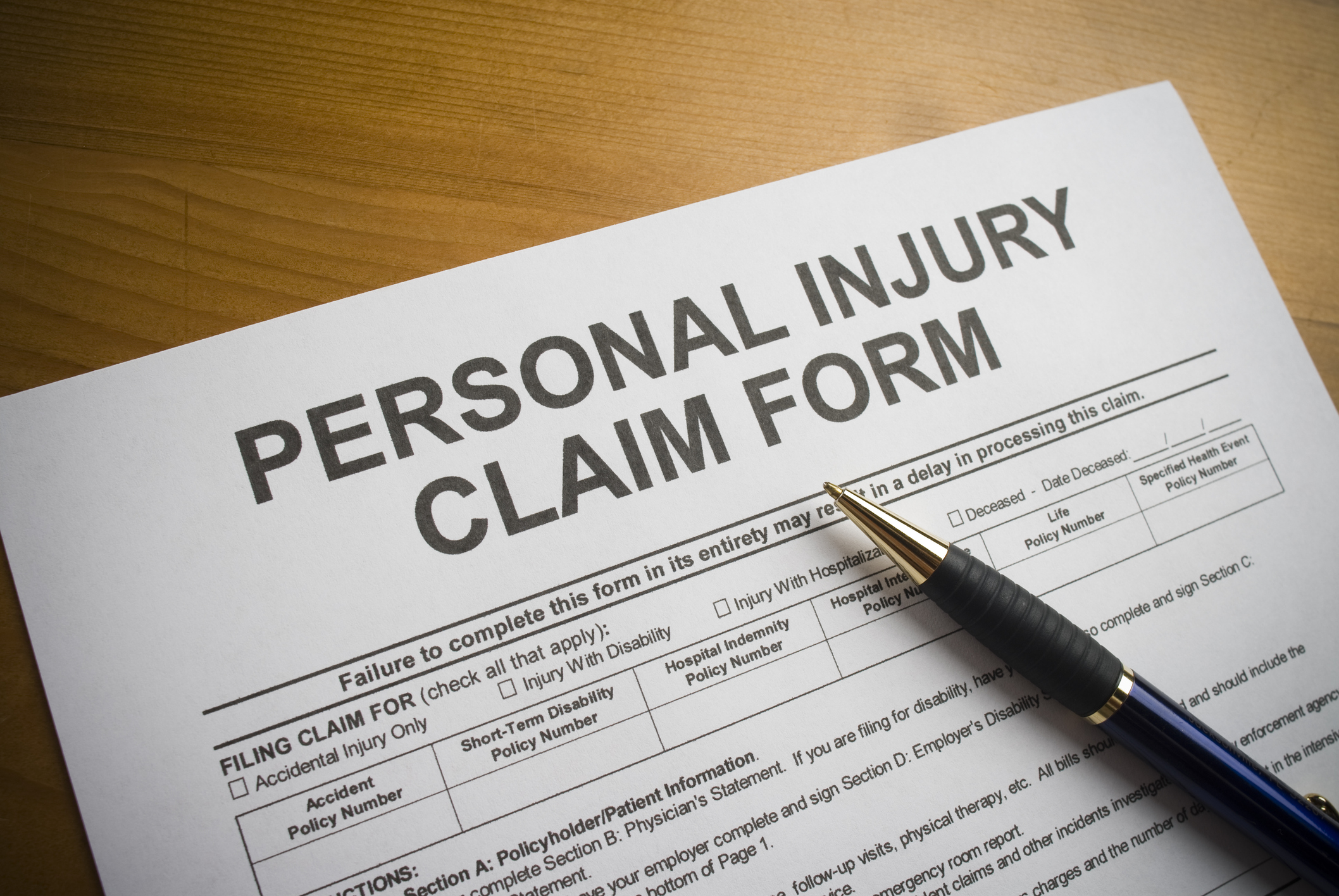 A personal injury claim form with a pen on top.
