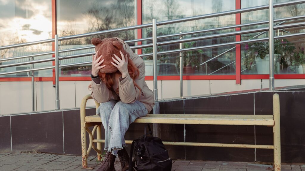 A woman stressing while sitting on a bench,